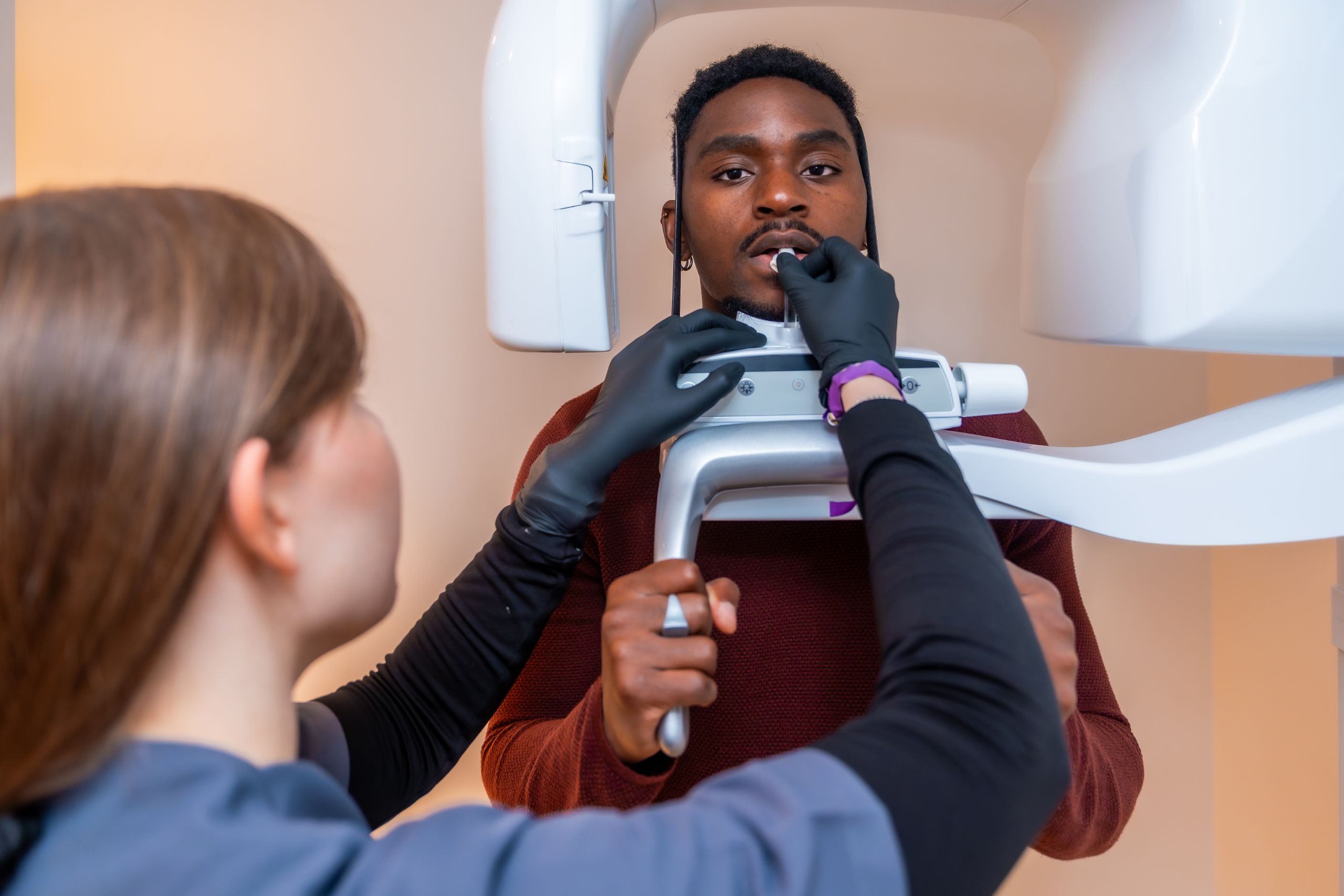 Dental staff positioning a patient in a panoramic X-ray machine for imaging at Vinings Modern Dentistry