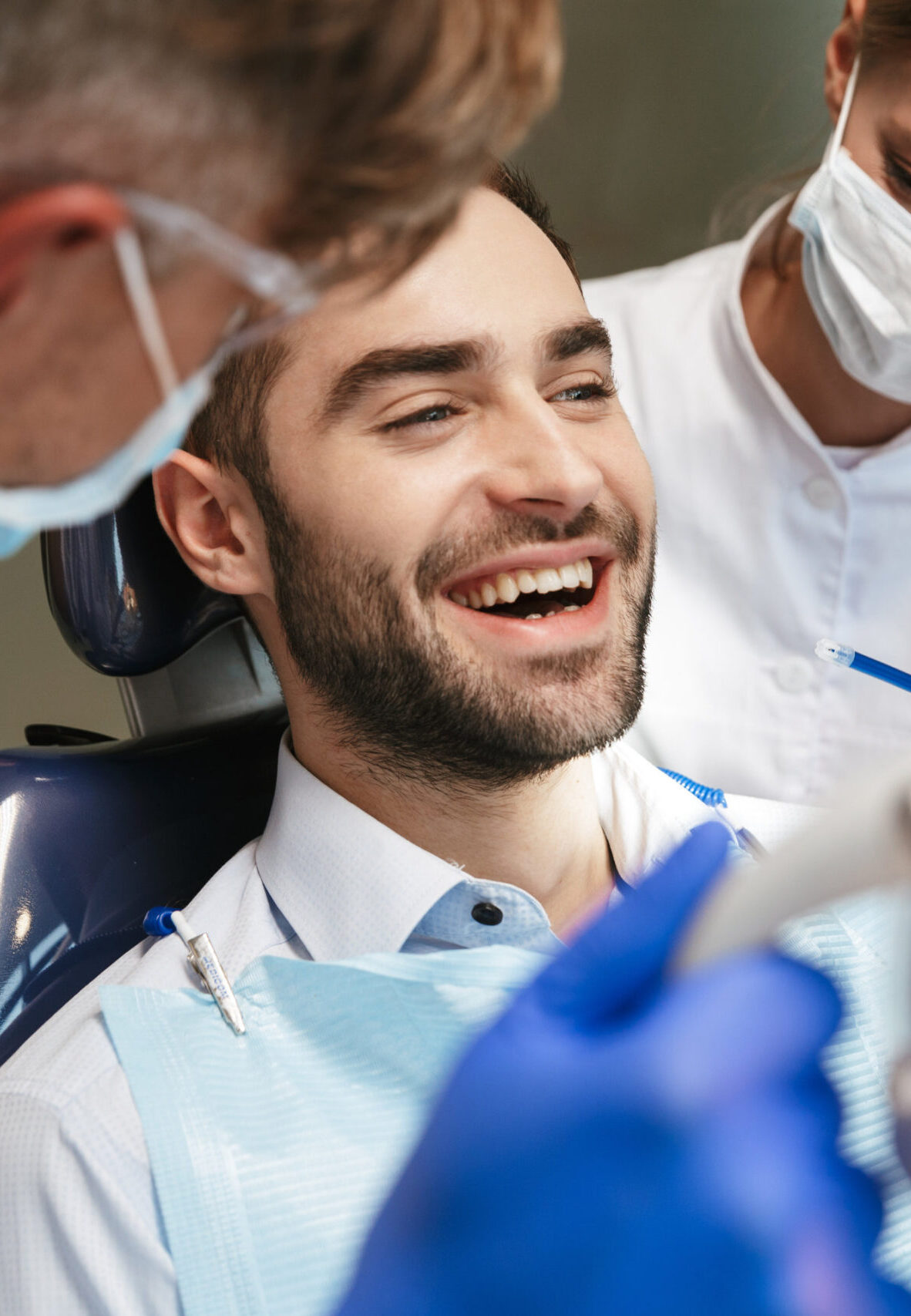 Image of a handsome happy young man sitting in medical dentist center.
