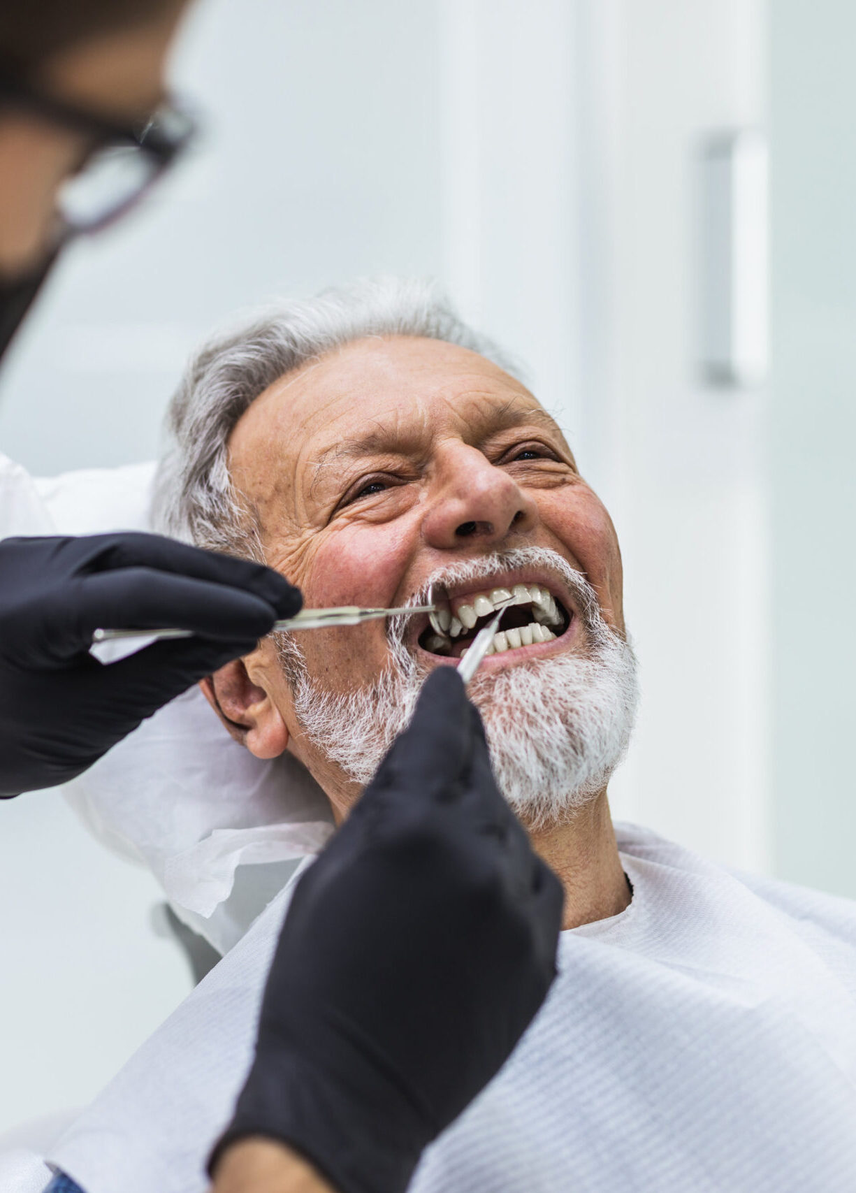 Senior man having dental treatment at dentist's office.