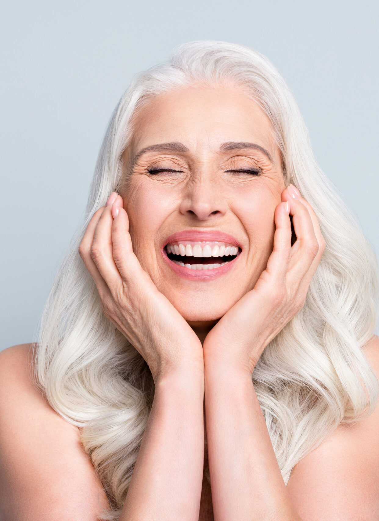 Close-up portrait of her she nice attractive excited cheerful grey-haired elderly lady touching cheeks laughing isolated gray pastel color background.
