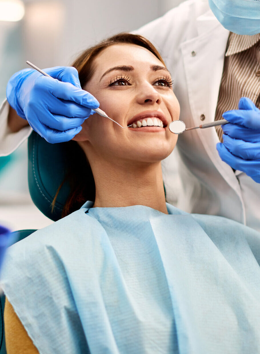 Young smiling woman having dental exam at dentist's office.