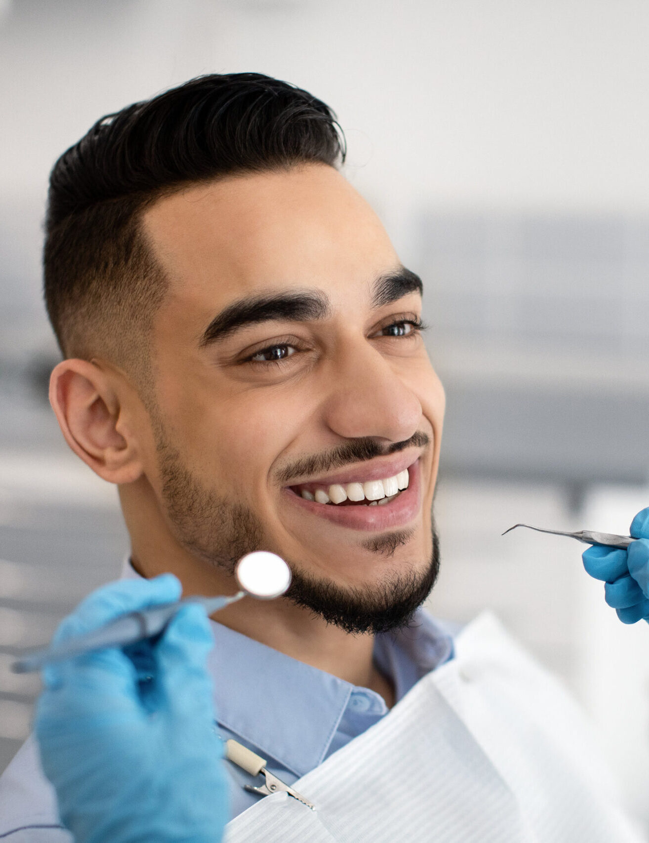 Closeup Of Happy Middle Eastern Male Patient Getting Dental Treatment In Modern Clinic, Islamic Dentist Woman Examining Teeth Of Arab Man With Sterile Tools In Stomatological Cabinet, Cropped Shot