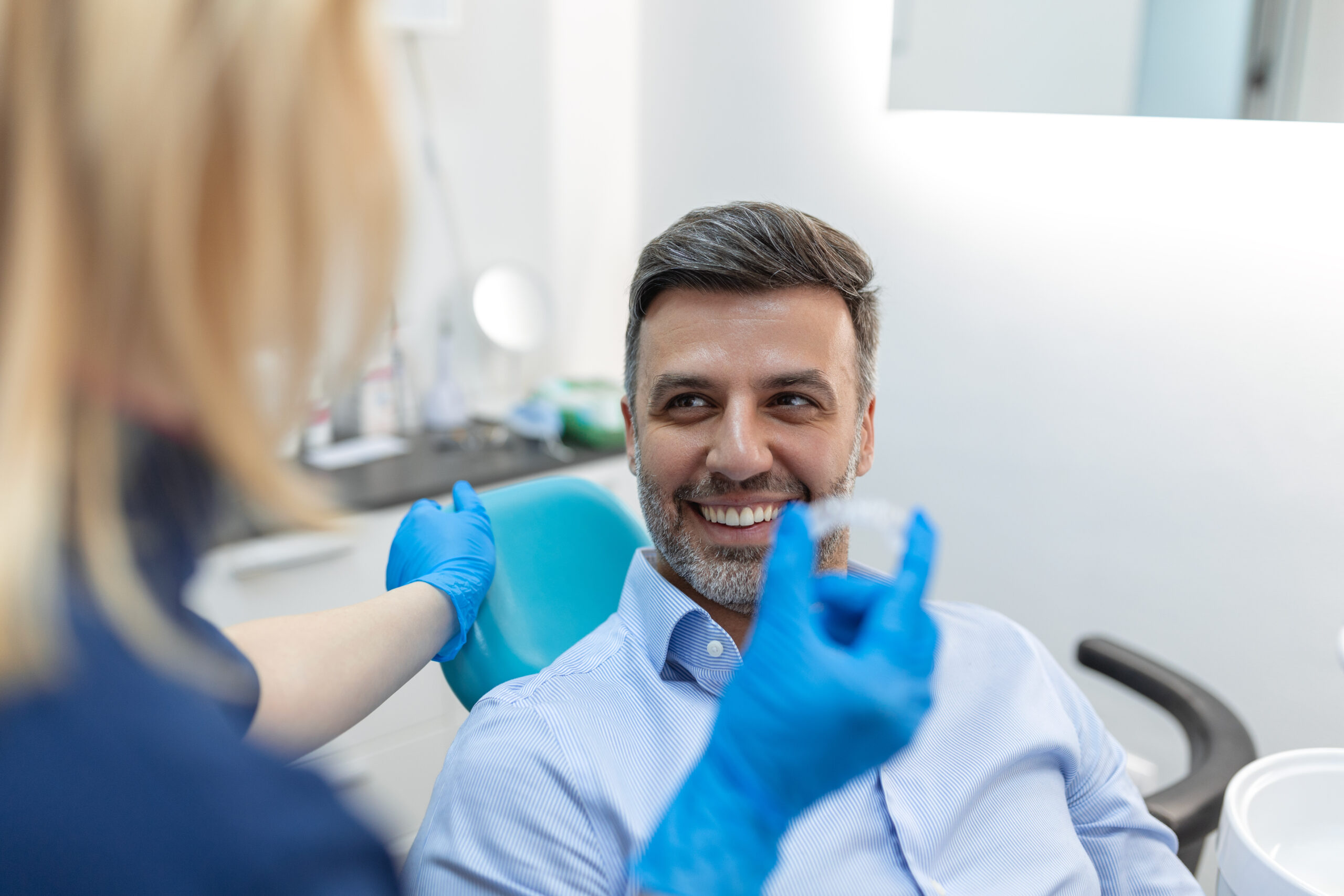 A young female dentist showing invisalign to patient in dental clinic, teeth check-up and Healthy teeth concept