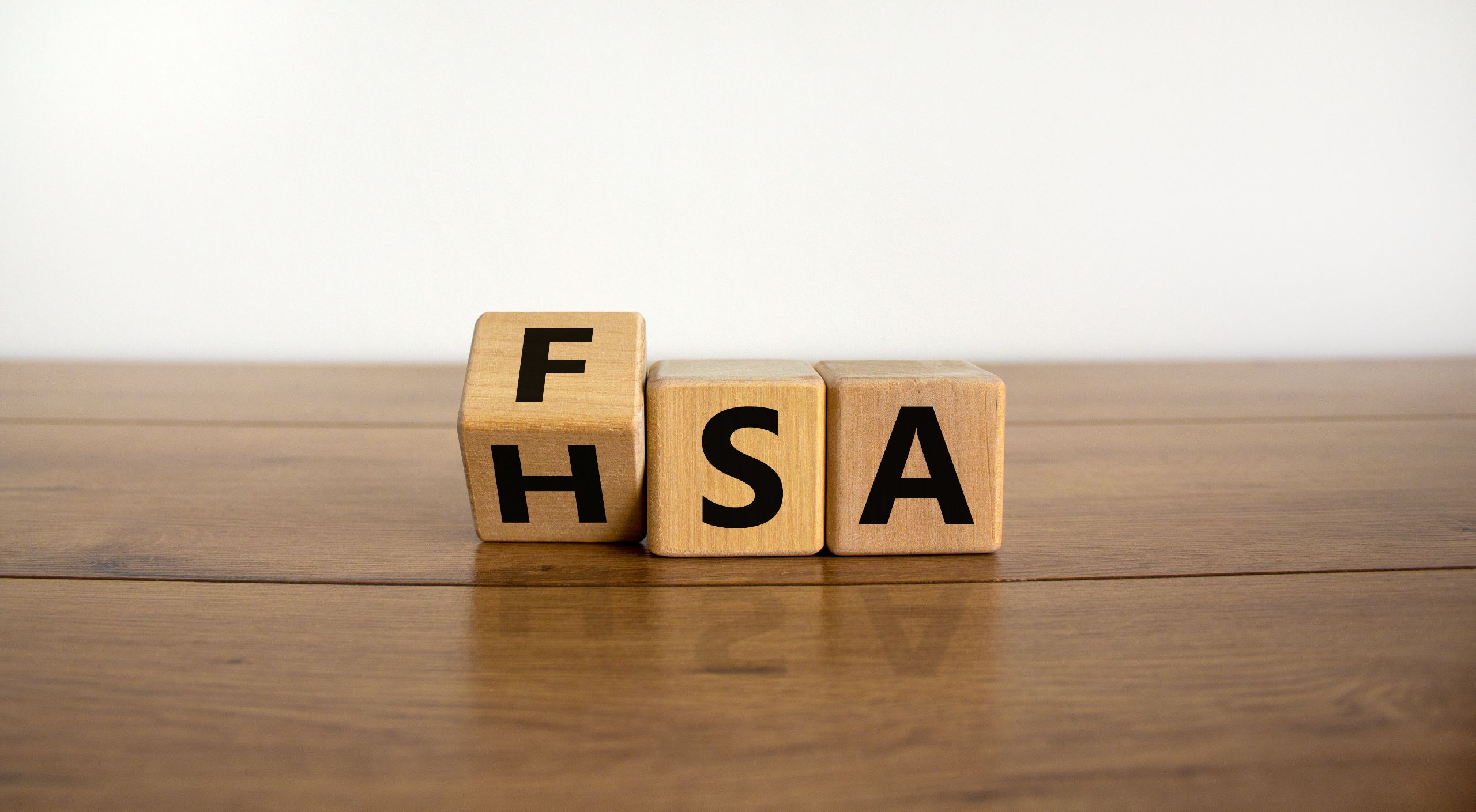 Wooden blocks spelling FSA and HSA on a table