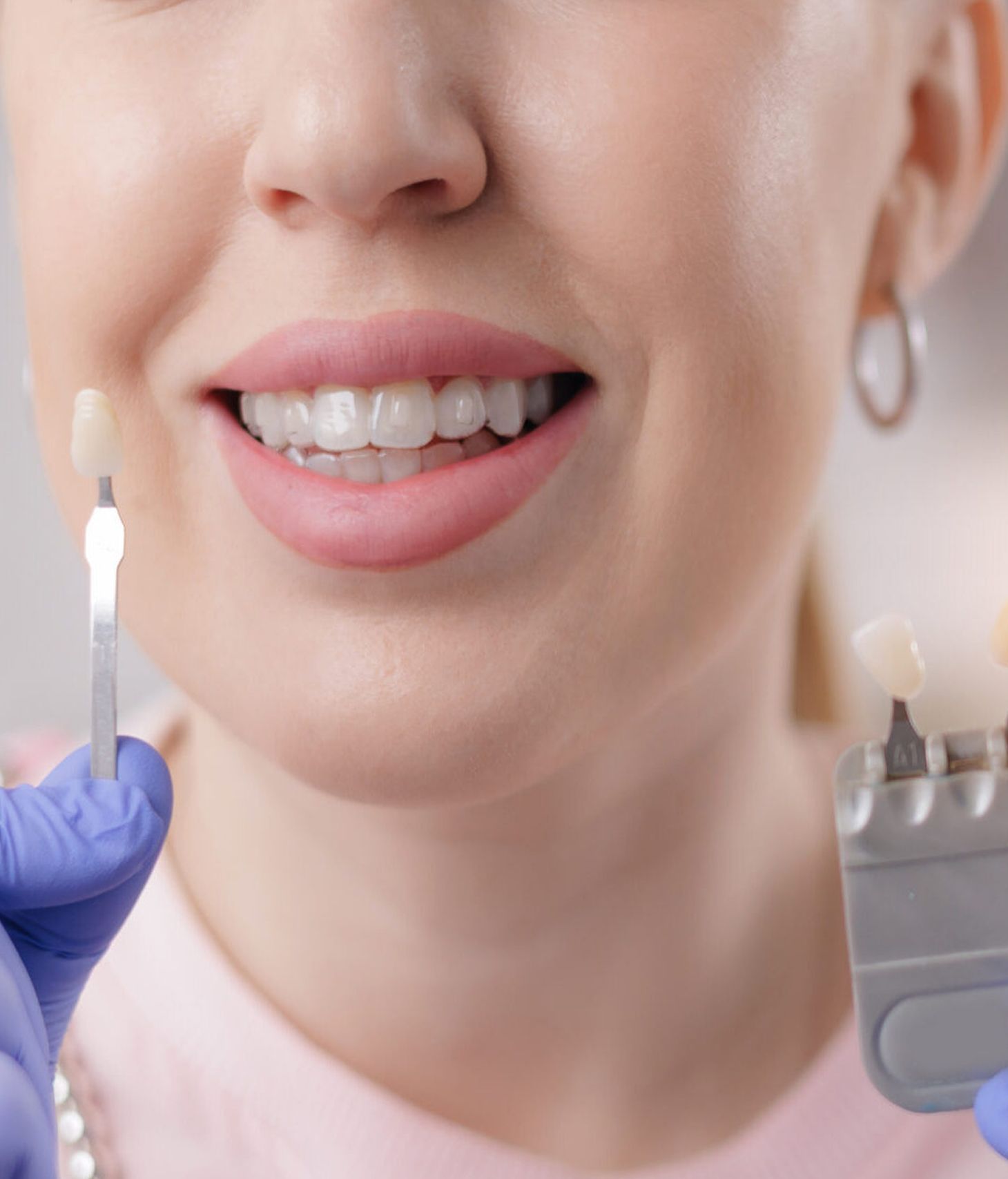 Caucasian female choosing dental veneers at dentist office.