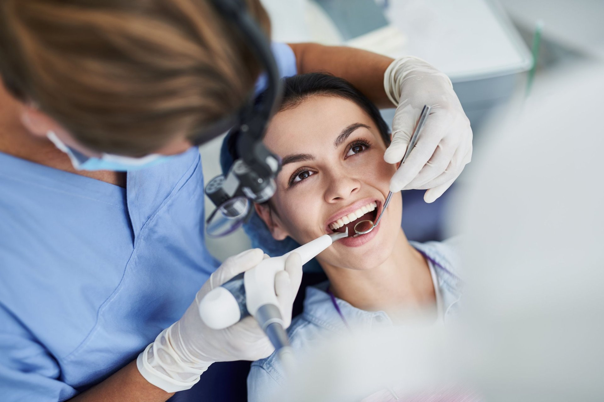 Dentist using magnification loupes during a cosmetic dentistry exam