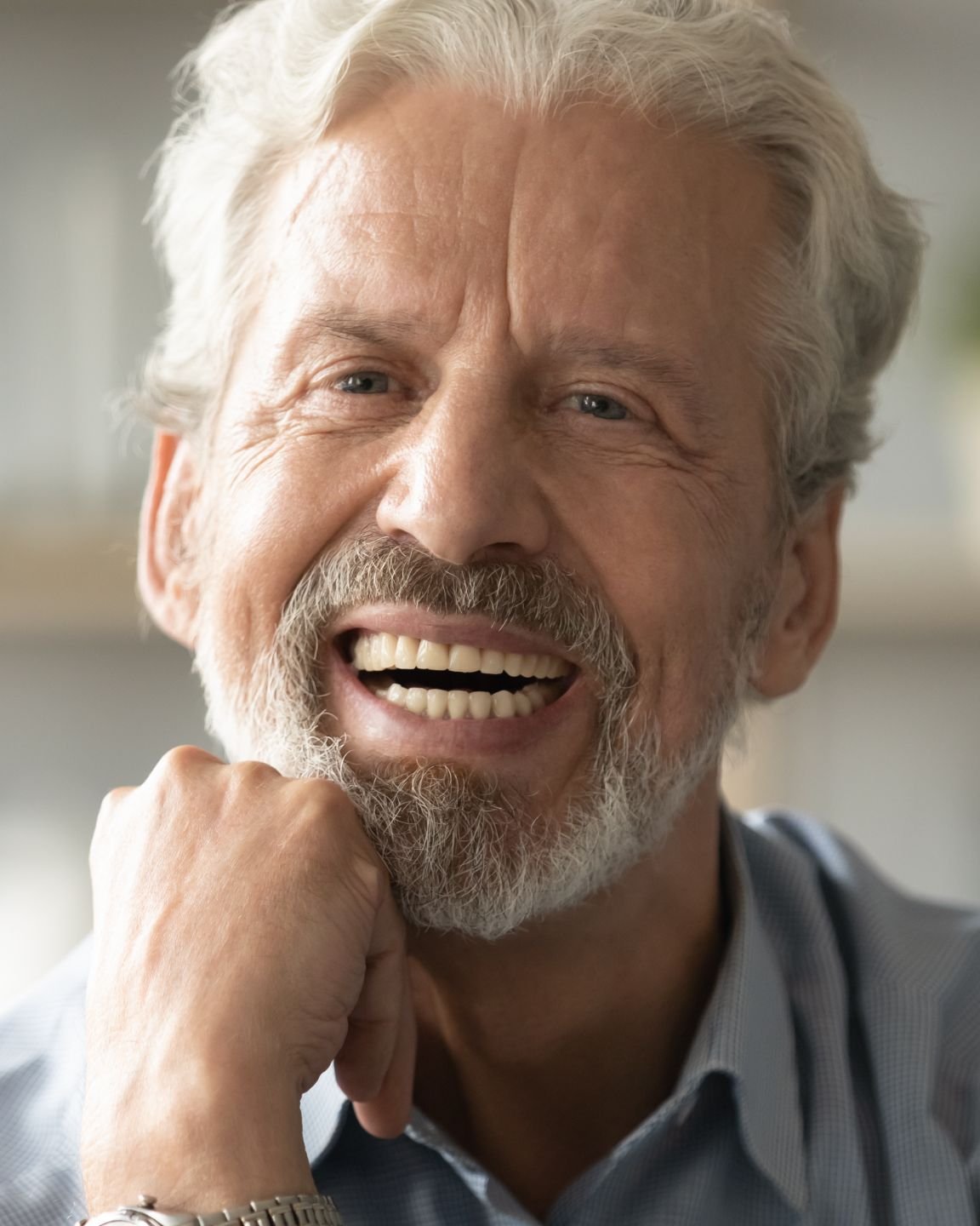Older man smiling confidently, representing a smile makeover