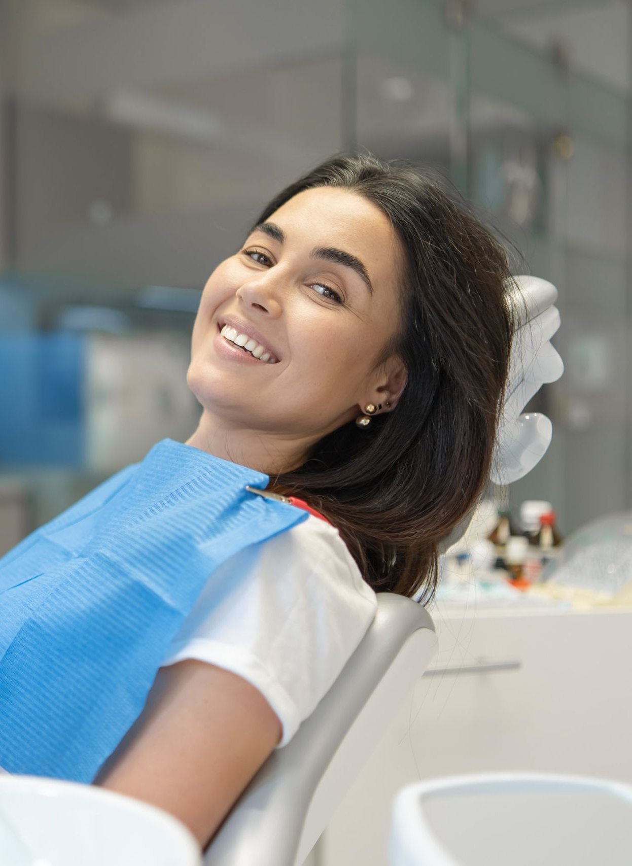 Smiling patient reclining in a dental chair during a smile makeover consultation