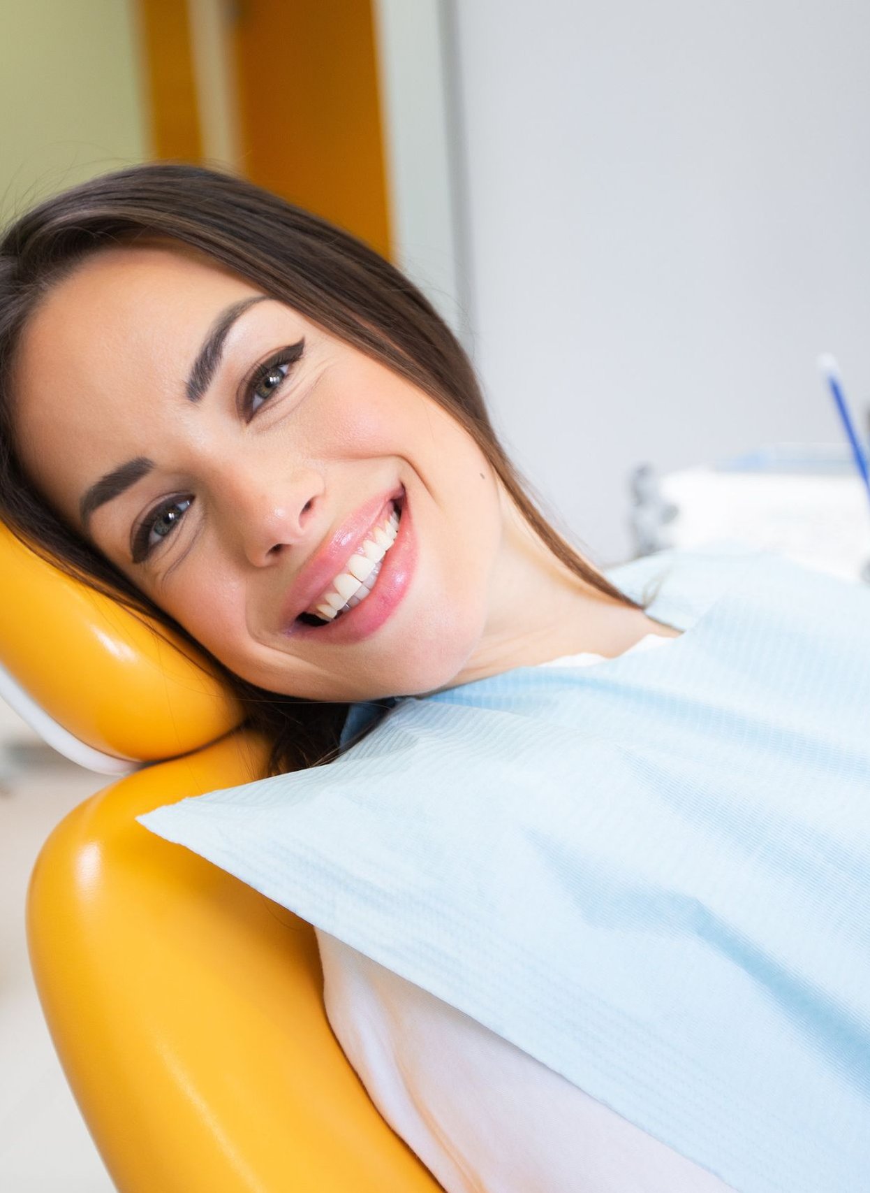 Patient smiling in a dental chair at a smile makeover consultation