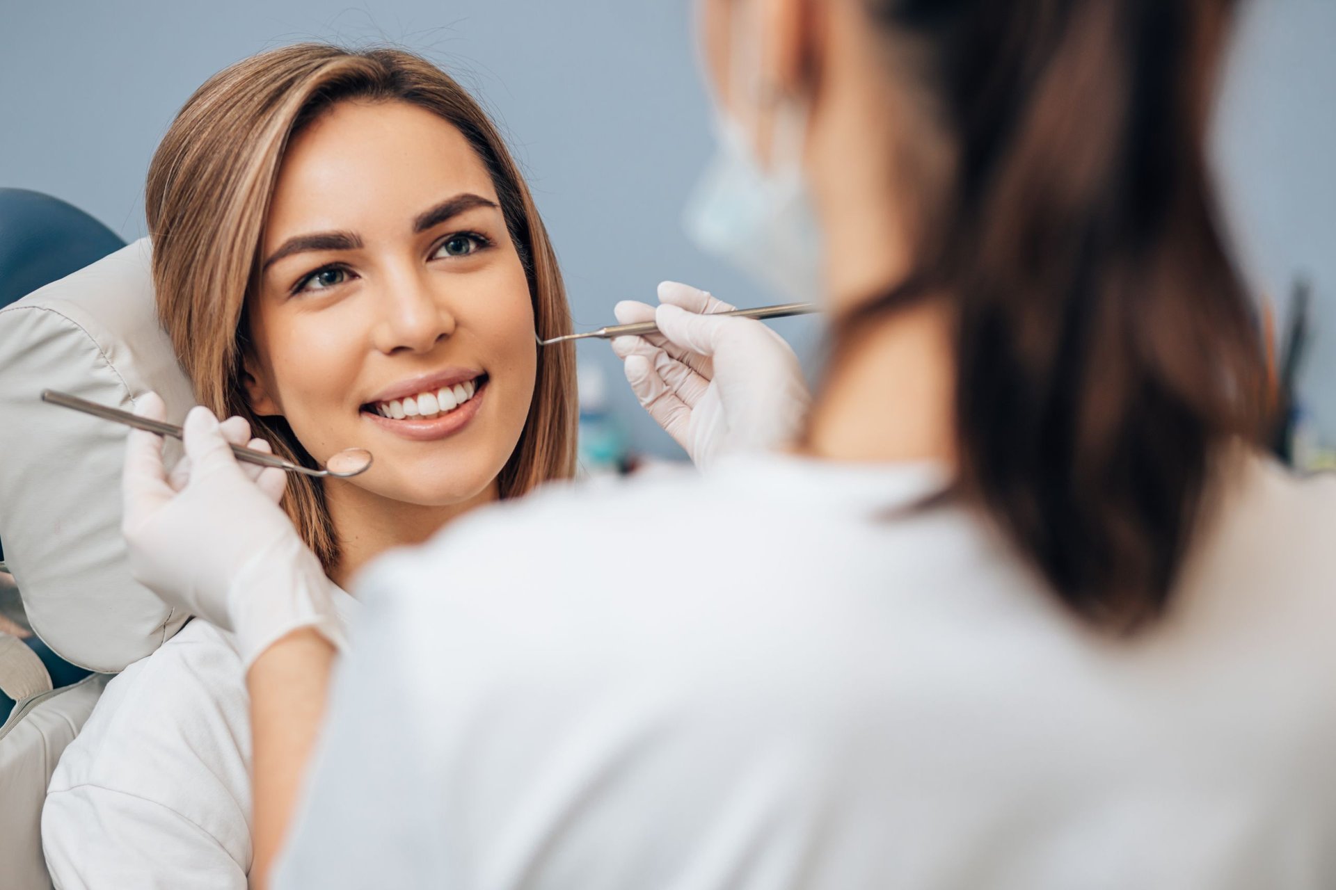 Dental team examining a smiling patient during a cosmetic consultation