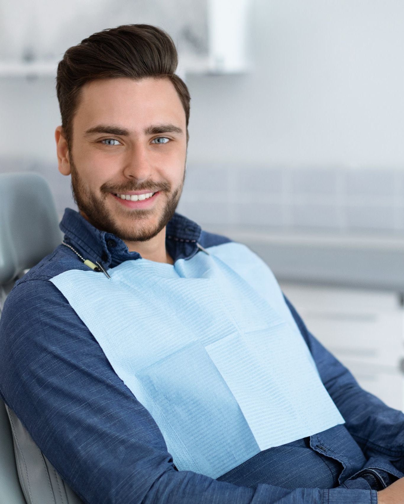 Smiling man seated in a dental chair before a whitening visit